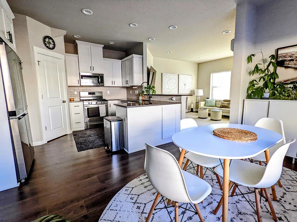 Open-concept kitchen and dining area with quartz island and stainless steel appliances.