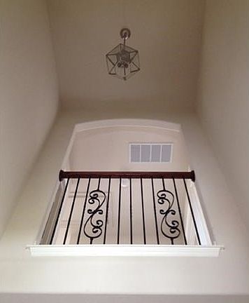 looking up at the entry you see this elegant Iron railing with artistry detailing on the second level.