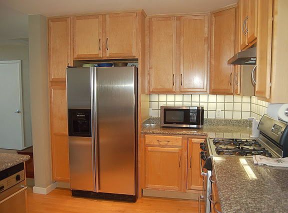 Kitchen with gas cooktop, dishwasher, fridge.