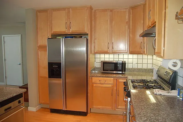 Kitchen with gas cooktop, dishwasher, fridge.