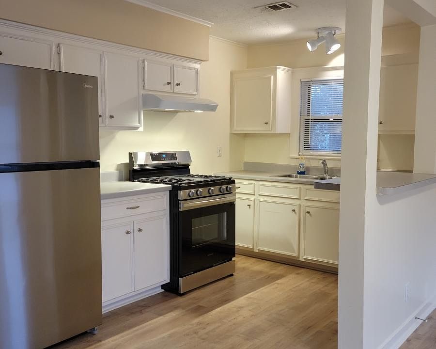 Kitchen with new refrigerator, new oven, and new floors.