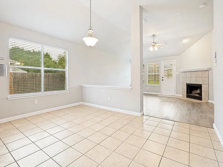 Large space to be used as dining room or breakfast room area with tiled floor and blinds on window.