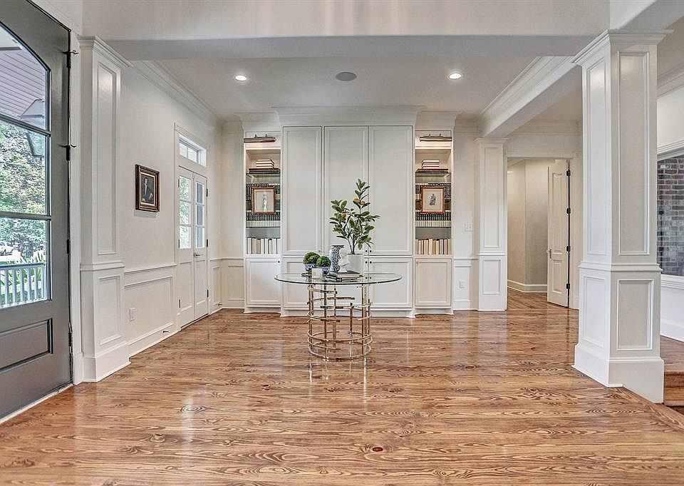 Recently added floor to ceiling built-ins were installed and lit by Restoration Hardware art lights, to provide a functional yet clean and elegant statement the moment you walk through the doors. This clean and all white Foyer allows views of the poo