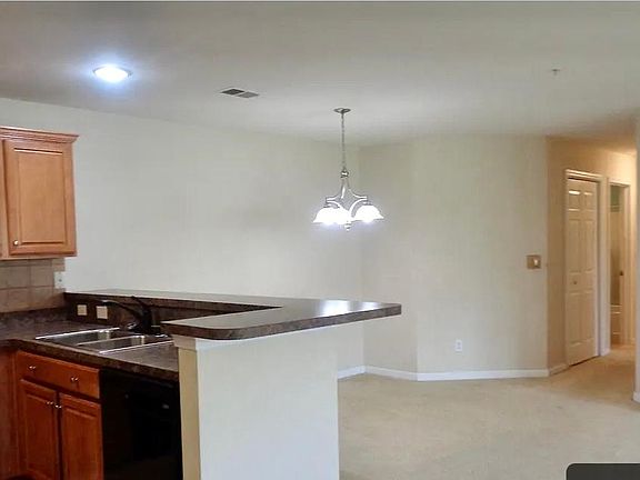 Kitchen has area for stools for countertop dining and dining room space.