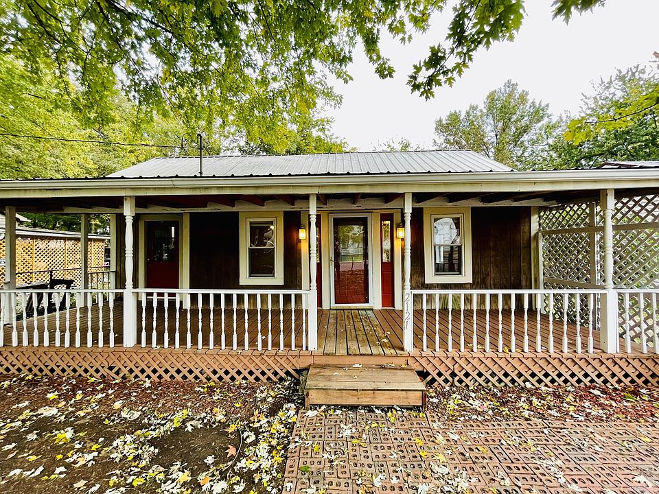 Roofed in front oversized front porch with a fenced in front yard as you enter