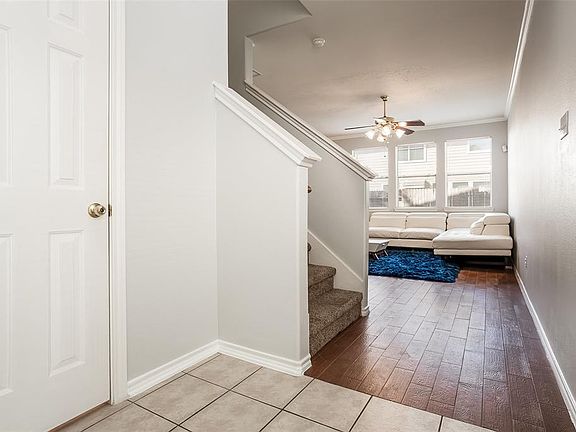 The Half Bath is to the Left on Entry, with Wood Look Tiled Floors in Living Room and Stairway Up to second story Bedrooms.