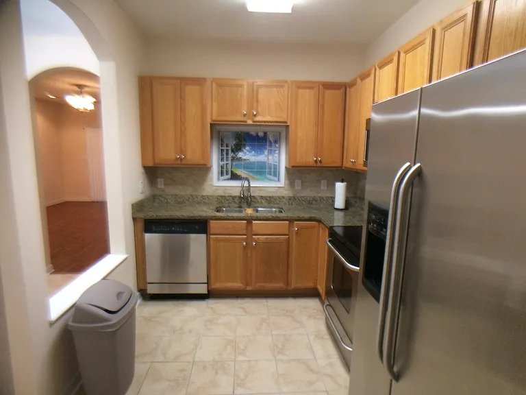 A view of the dishwasher and kitchen sink. To the left of the dishwasher is the dining area.