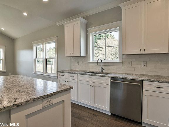 Bright kitchen, granite counters, tile backsplash.