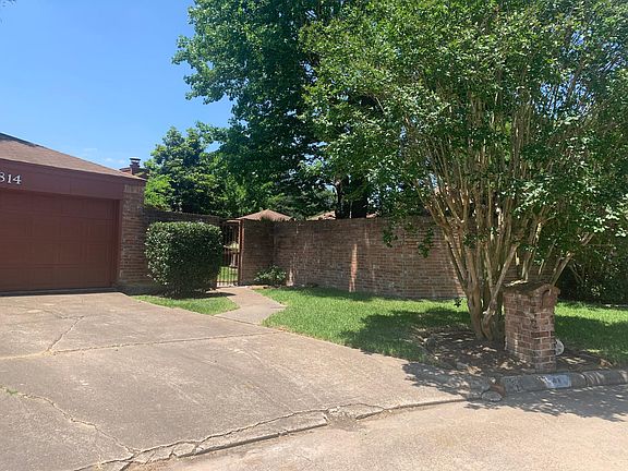 Gorgeous front yard with large brick wall & gate for privacy & security.