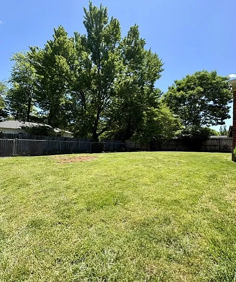 Privacy fenced backyard with established landscaping
