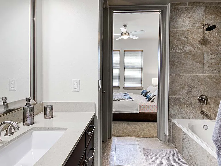 Griffis Uptown apartment bathroom with tiled shower tub.