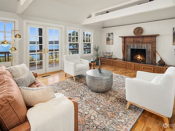 Enter into the gracious living room with hardwood floors, wood-burning fireplace and french doors out onto the generous view deck.>