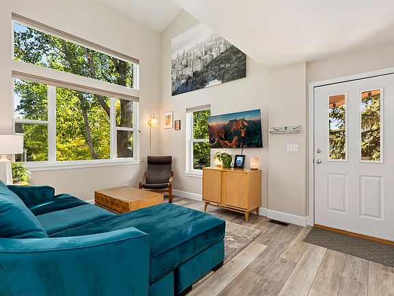 Living room, large windows, wall-mounted TV, new couch with down cushions and chaise.