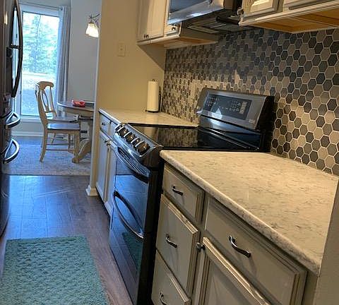 Newly updated and modern kitchen and view of living room.
