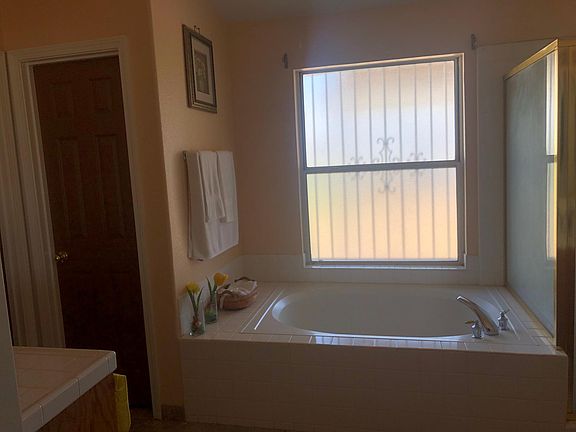 master restroom with bath tub, shower, and his and her sinks