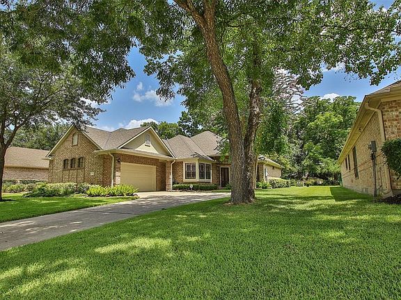 Fully shaded driveway and view of the park behind the house.