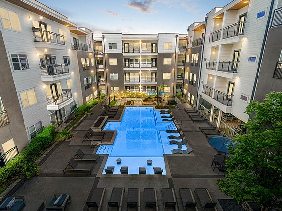 Resort-style pool area complete with sun shelf, lounge seating and fire feature