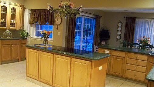 Huge party kitchen with maple cabinets and Corian countertops.