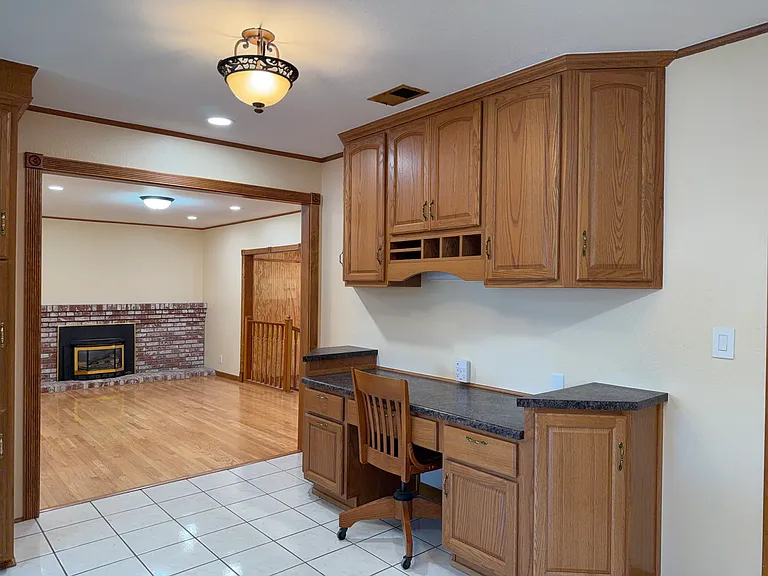 Built-in desk nook off the kitchen, opens to family room with fireplace