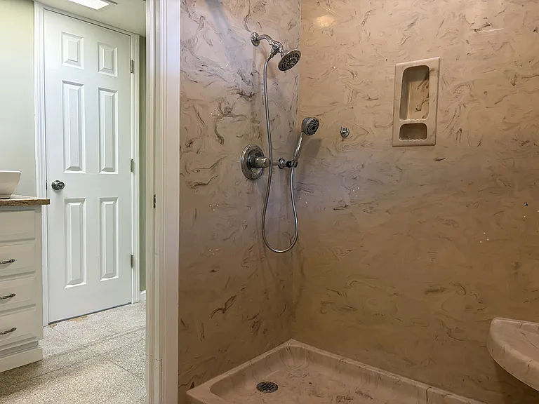 Spacious primary bathroom with a double-sink vanity, walk-in shower, and generous cabinet storage.