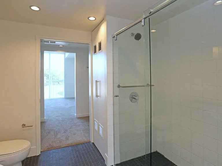 Bathroom with closed laundry doors and clostes for front bedroom at 12th Street Lofts in National City, California.