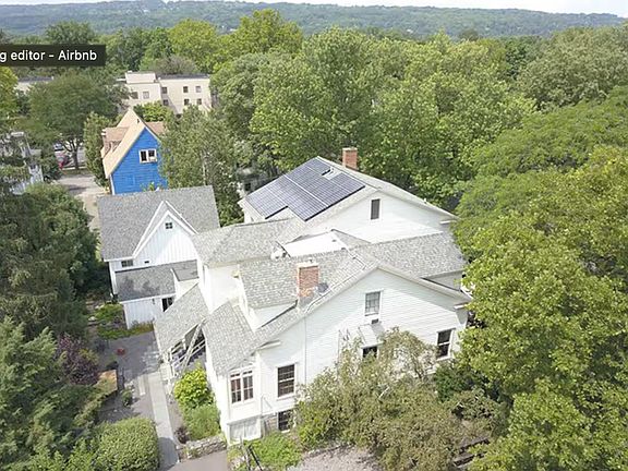 Our home and adjacent Carriage House in white, notice solar panels.