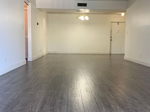 Large living area with dining and living room areas. Bedrooms are on both sides of living area for privacy