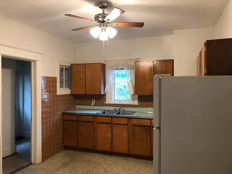 Double bowl stainless steel sink, ceiling fan, space for table, exit to door to the backyard