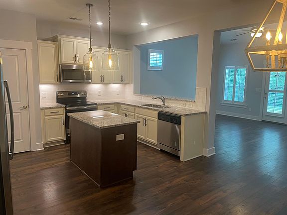 Centralized kitchen with stainless appliances and granite countertops