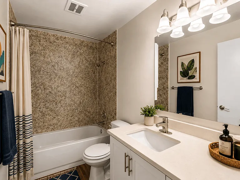 A bright, stylish bathroom with modern finishes and a convenient tub and shower combination at Chambers Pointe Apartments.