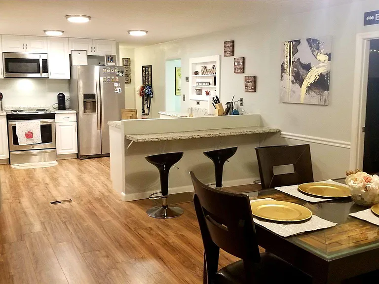 **View with previous flooring. Recently updated with new tile throughout. View from dining room to kitchen showcasing open floor plan.