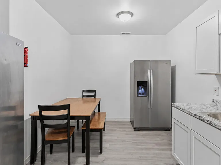 Eat-in kitchen with a dining table, generous counter space, and stainless steel side-by-side refrigerator with ice/water.