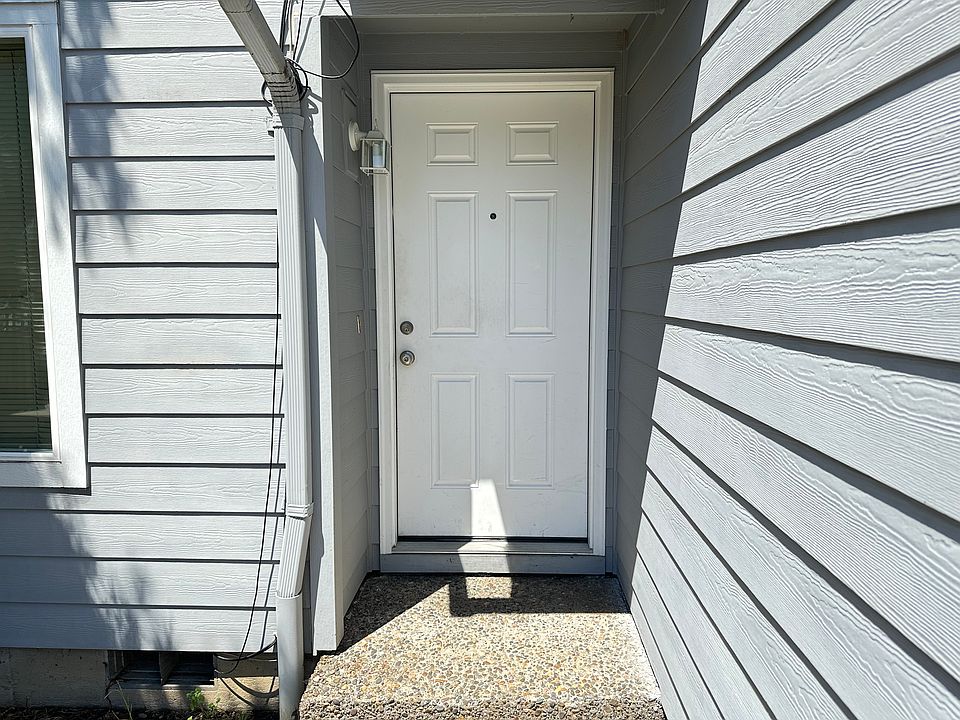 Front door with peephole, light, and doorbell