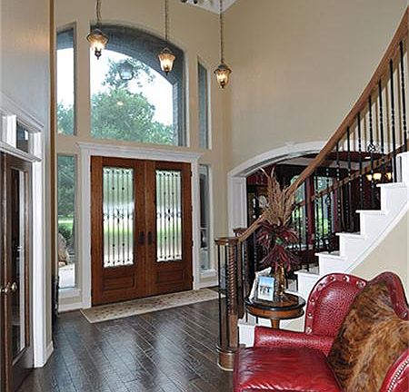 Foyer boasts beautiful hardwood floors, chandelier, and lots of windows for natural light.