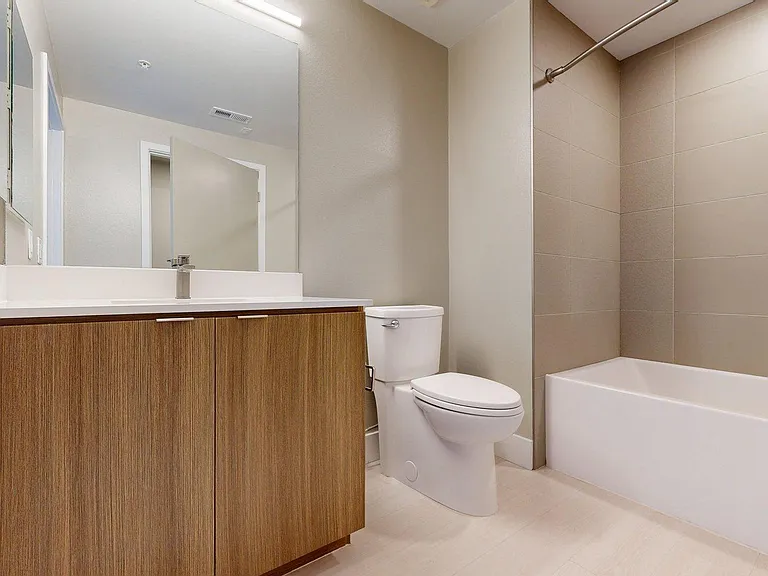 Apartment Bathroom with large soaking tub, vanity mirror and Wood-Style Flooring.