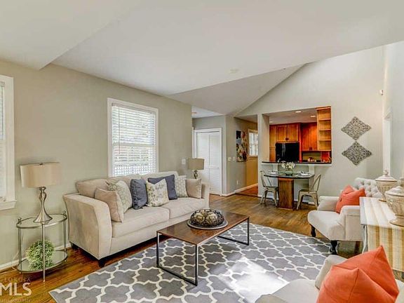 Spacious living area, bright natural lighting from the windows and sunlight. Gas fireplace surrounded by built in bookcase and storage.