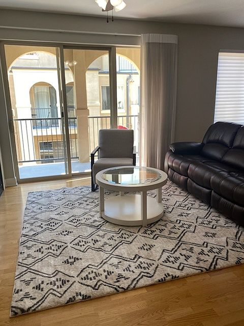Living room is furnished and offers cozy sitting room with double doors opening to the balcony. The balcony overlooks the courtyard and offers a mountain view.
