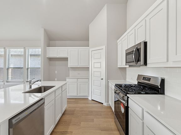 Kitchen in the Claret home plan by Trophy Signature Homes - REPRESENTATIVE PHOTO