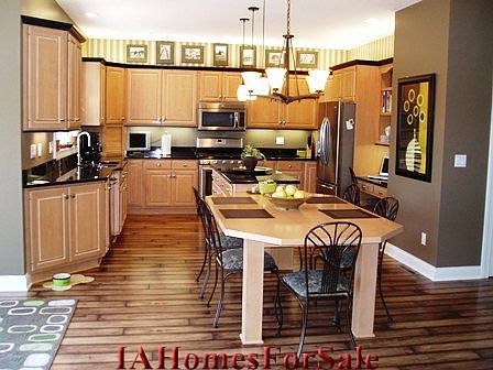 Kitchen has high-end vanilla-glazed maple cabinetry, gorgeous granite, built-in custom maple informal dining area, stainless steel appliances and a walk-in pantry.