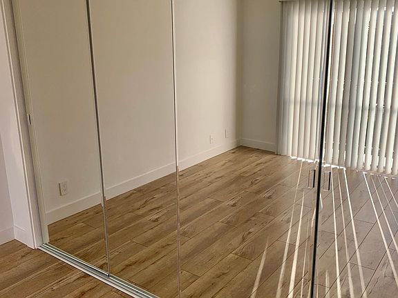 Bedroom closet has fully mirrored doors