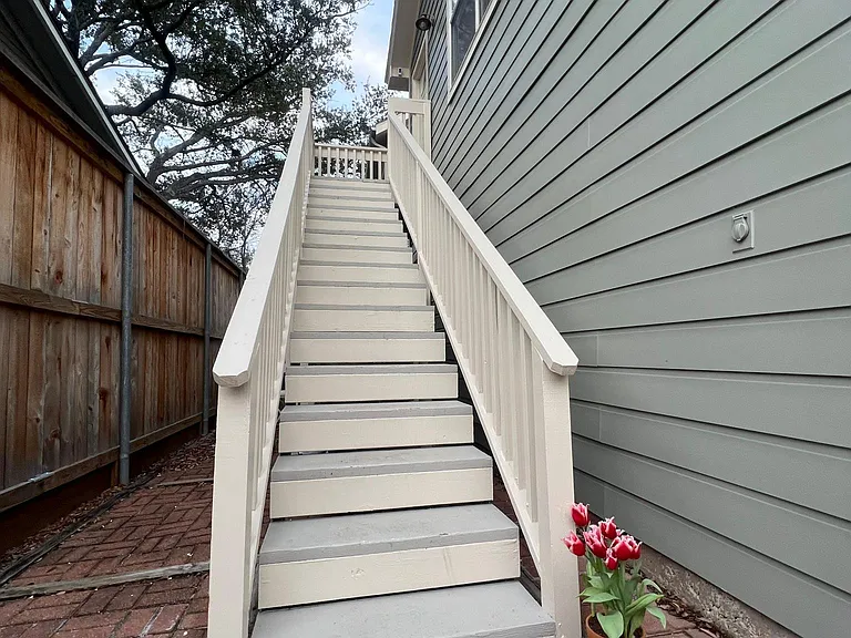 Stairs leading to apartment with small outdoor patio area.