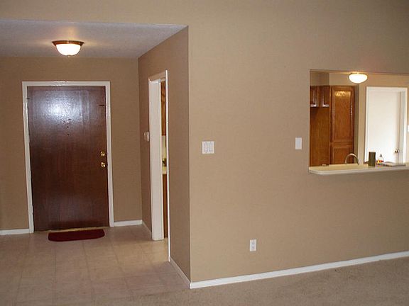 Living room looking to front door and kitchen pass through.