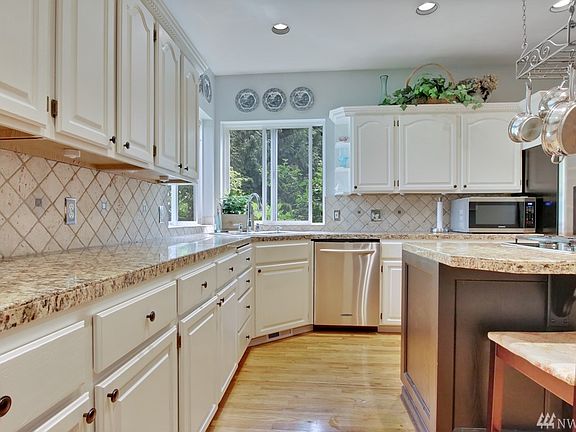 Chef's kitchen boasts hardwood flooring, granite counter tops, tile backsplash & plenty of natural light!
