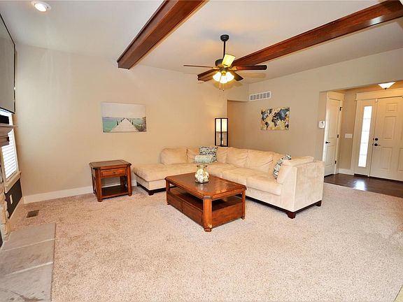 Great Room with wood beams add a touch of beauty and charm! Gas fireplace with stone style surround and custom mantle.