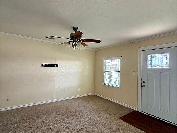 Spacious living area with ceiling fan and abundant natural light.