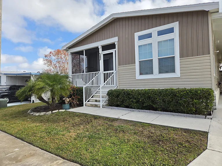 Welcoming front entry way with securely locked screen door 3-car driveway with carport