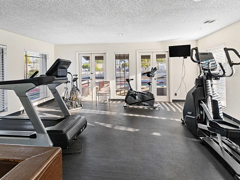 Top floor of two-story fitness center overlooking tennis and pickleball courts