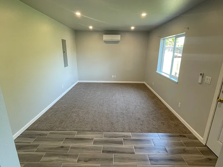 Family room with mini split and soft carpet. East facing window.