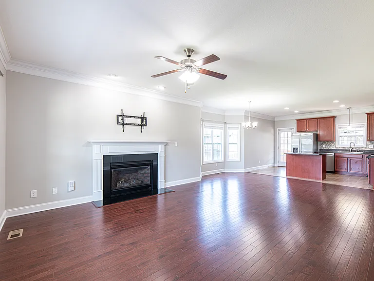 Living room features hardwood floors, a gas fireplace and a heavy-duty TV mount compatible with 42"_90" TVs supporting up to 150 lbs.