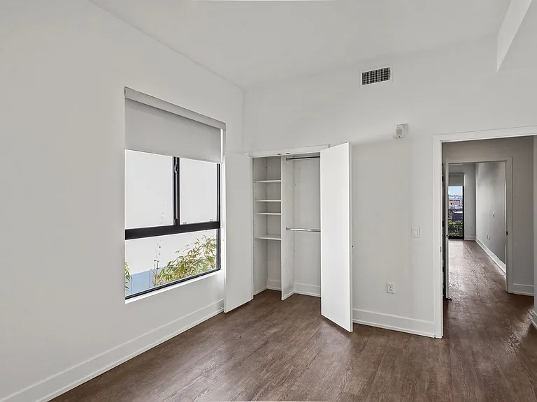Bedroom with Windows with Shades and Closet with Built-In Shelving